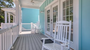 A covered porch with white railings and chairs, a ceiling fan, and a door with glass panels. - Private Pool! Walk to Beach! Ping pong! Arcade! (Murrells Inlet)