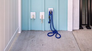 A light blue door with a white mailbox and a blue hose on the ground. - Beach Home! Private Pool! Arcade-Beach-FUN! Elevator (Murrells Inlet)