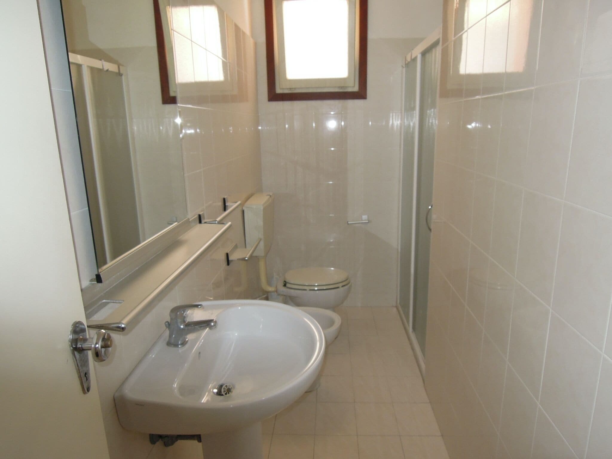 A small, clean bathroom with a sink, toilet, and shower.