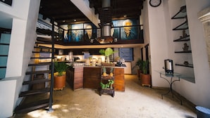 A kitchen with a central island, wooden staircase, and a clock on the wall. - 8APS-4 CASA ANTIGUA EN EL CENTRO HISTORI (Cartagena)
