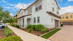 A two-story residential building with a covered patio, a garage, and a driveway. - Gilbert Haven: A Family Delight in Enchanting Community (Gilbert)