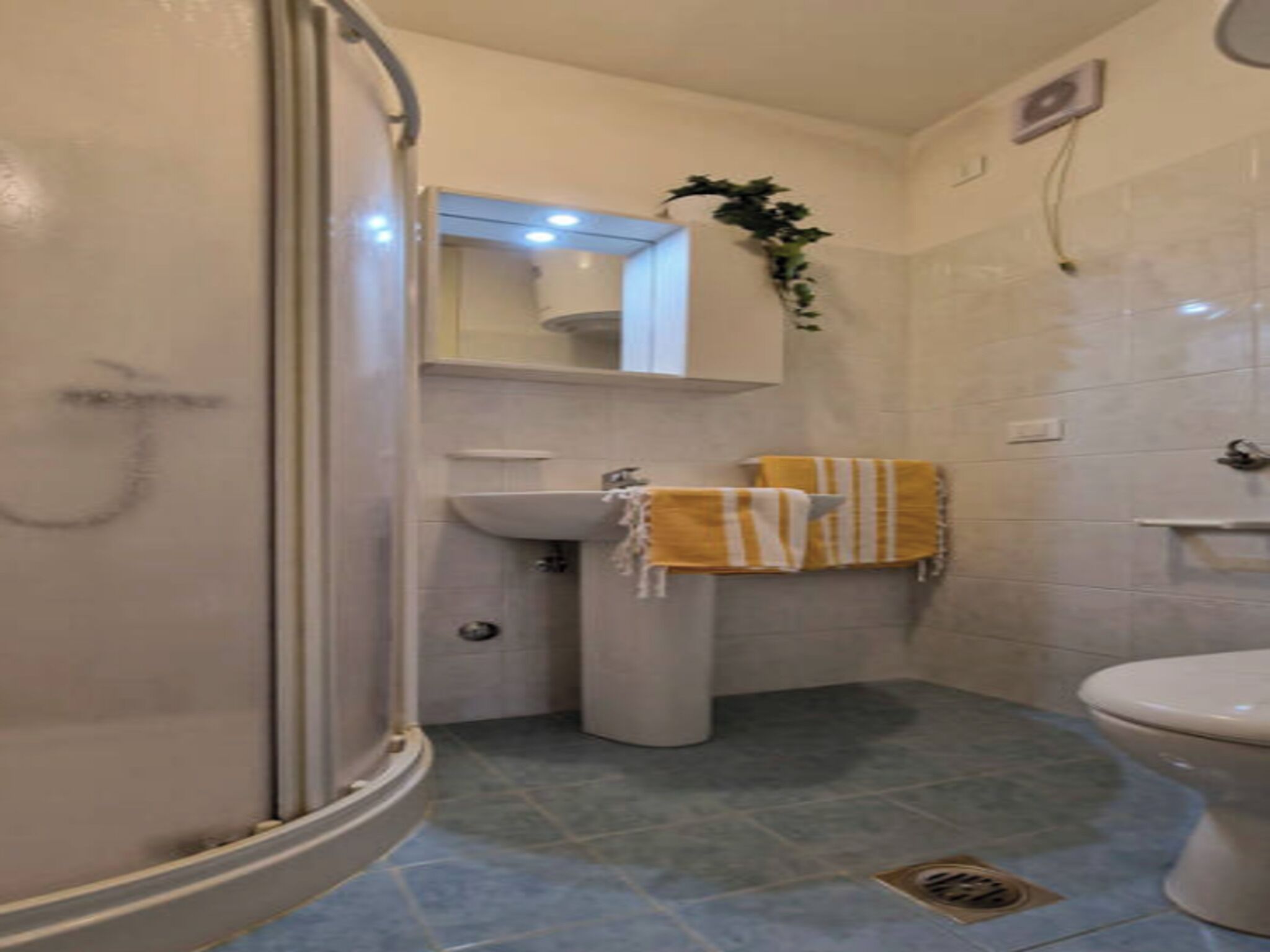 A bathroom with a shower, sink, and toilet.