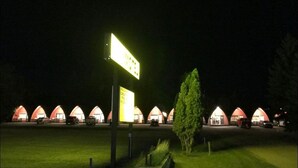 A row of red-roofed cottages with a signpost in the foreground. - The little chalet motel (Brandon)