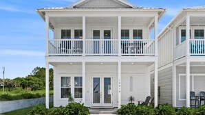 A two-story beachfront house with a balcony, a front door, and a small porch area. - Private Pool, 30A Life in PCB, Laguna Beach Pearl (Panama City Beach)