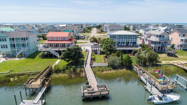 A coastal residential area with a dock, a boat, and houses with balconies.