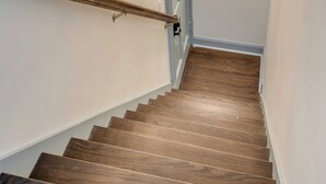A staircase with wooden steps and a wall-mounted light fixture. - The Manor 93 - B Beautiful Three Bed Three Bath Close to King St. (Charleston)