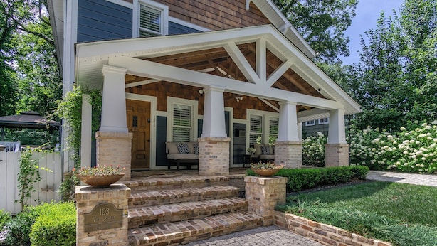 A two-story house with a covered porch, brick steps, and a stone mailbox. - View Street Retreat | Pet Friendly, Fenced Yard, Walk to Town! (Black Mountain)