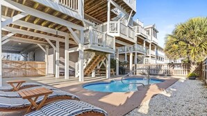 A multi-level wooden building with outdoor seating and a pool.