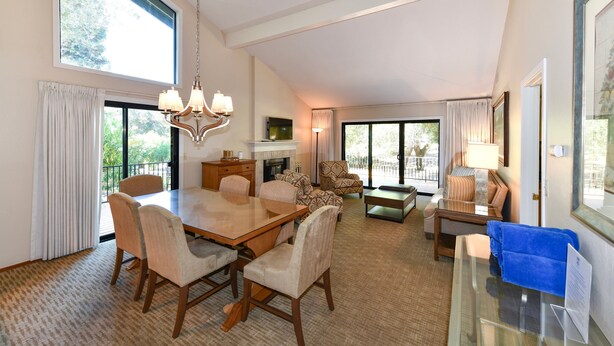 A spacious room with a dining table, chairs, a sofa, a TV, and a fireplace. - Private Golf Resort Setting 3 bedrooms (Napa)