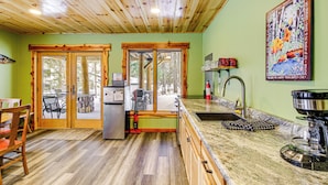 A kitchen with wooden ceiling, green walls, and a painting of a dog. - Pokegama Lake Vacation Rental w/ Shared Boat Dock! (Grand Rapids)