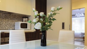 Una cucina moderna con elettrodomestici bianchi, un tavolo in vetro e sedie bianche.