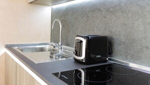 A modern kitchen with a built-in toaster, stainless steel sink, and a sleek countertop.