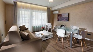 A modern living room with a sofa, coffee table, and dining table with chairs.