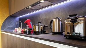 Una cocina moderna con electrodomésticos de acero inoxidable, incluyendo un hervidor, un tostador y una olla sobre la encimera.
