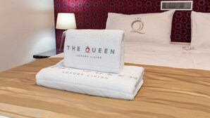 A hotel room with a bed, a nightstand, a lamp, and a wall with a patterned design.