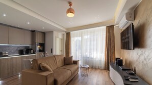 Una sala de estar moderna con un sofá, una mesa de centro y un televisor montado en la pared.