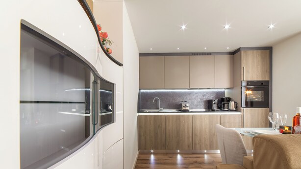 Una cocina moderna con un refrigerador empotrado, un microondas y una cafetera.