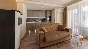 Una sala de estar moderna con un sofá, una mesa de centro y una cocina al fondo.