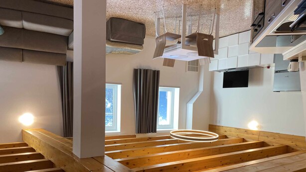 A modern interior with exposed wooden beams, a staircase, and a kitchen area with a microwave and cabinets. - Palazzo Maggiore Suite A (Noale)
