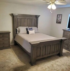Cozy retreat with a large bed, nightstand, and dresser, perfect for a restful stay.
