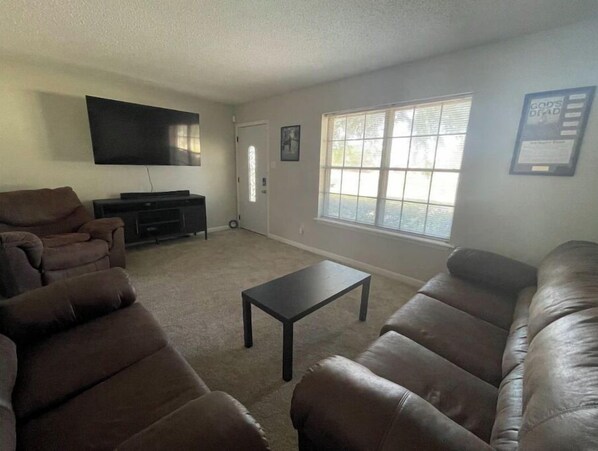 Relax in this cozy space with a large flat-screen TV, comfortable sofas, and a convenient coffee table.