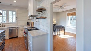 A modern kitchen with white cabinetry, a built-in stove, and a dishwasher. - Waterfront Home & Golf Getaway - Close to the Boardwalk and Assateague (Berlin)