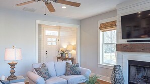 A living room with a sofa, coffee table, lamp, and fireplace. - Waterfront Home & Golf Getaway - Close to the Boardwalk and Assateague (Berlin)