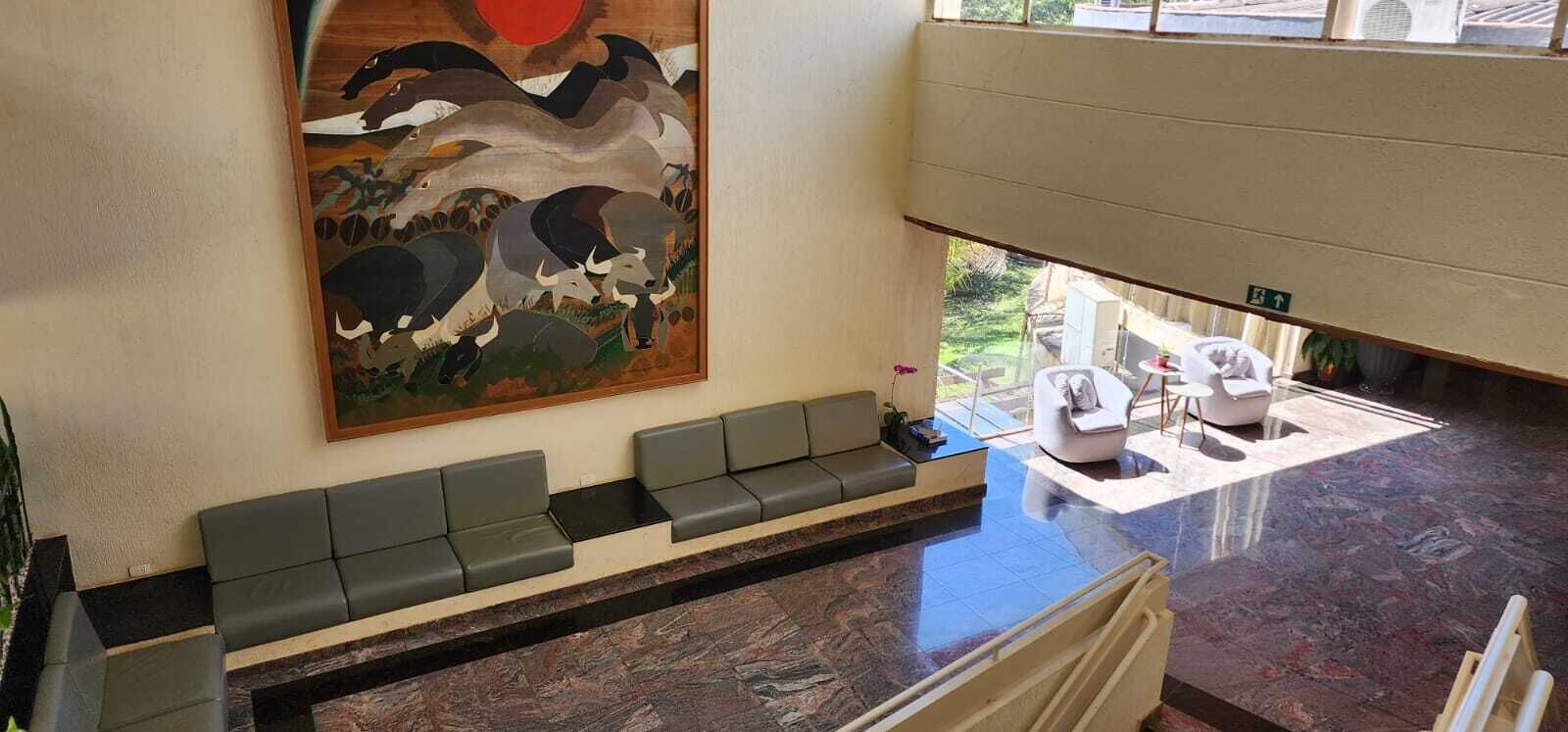 A reception area with a long bench, a painting of bulls, and a view of the outdoor area.