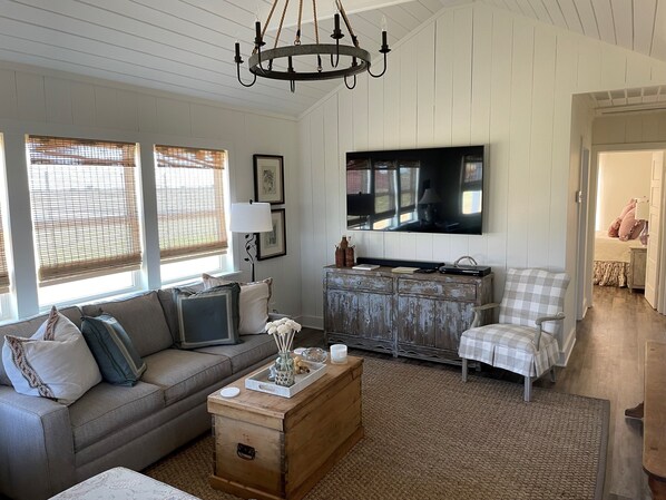 A living room with a sofa, a wooden coffee table, a television, and a vintage dresser. - MoonShiner Farm - Shiner TX (Shiner)