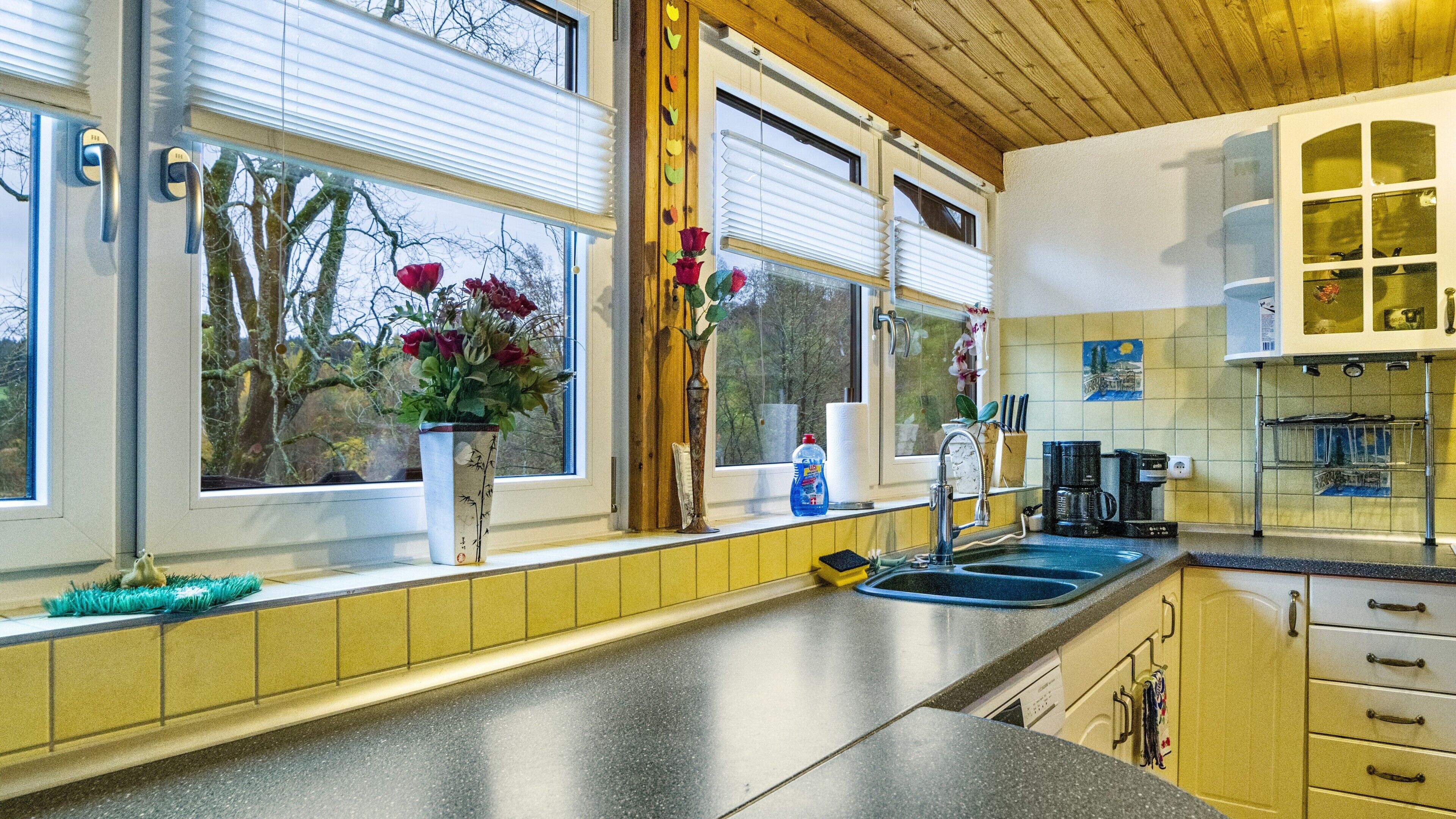 A kitchen with a window, a sink, and a coffee maker.