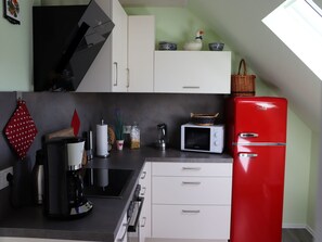 A kitchen with a microwave, coffee maker, and a red refrigerator. - Apartment "Rosenberger" with Mountain View, Balcony & Wi-Fi (Lennestadt)