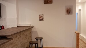 A kitchen with a wooden countertop, two stools, and a wall-mounted clock. - Apartment "1 Bartölke" with Private Terrace & Wi-Fi (Bockenem)