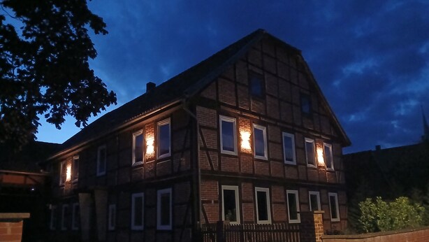 A two-story building with a traditional half-timbered facade, multiple windows, and a gated entrance. - Apartment "1 Bartölke" with Private Terrace & Wi-Fi (Bockenem)