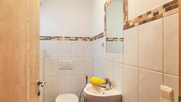 Ein Badezimmer mit Toilette, Waschbecken, Spiegel und Handtuchhalter.