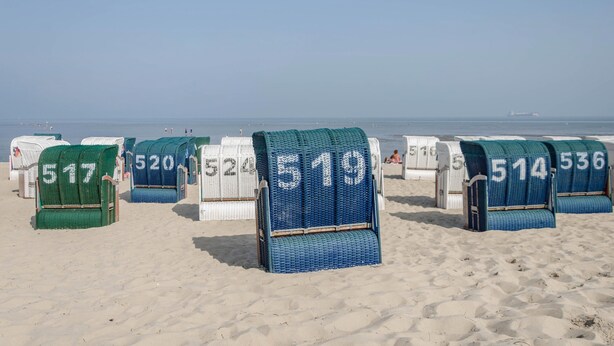 Beach chairs with numbers on them, arranged on a sandy beach. - Holiday Apartment 'Nordsee' with Shared Terrace, Shared Garden & Wi-Fi (Hooksiel)