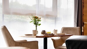 A dining area with a table, chairs, and a vase of flowers. - Apartment '-2-die Zwei, Studio 35qm' with Private Terrace, Shared Garden and Wi-Fi (Rosenfeld)