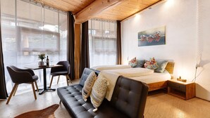 Una camera da letto moderna con un letto, un divano, un tavolino e una sedia.