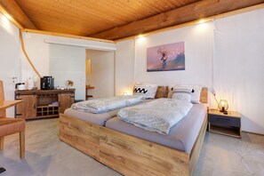 A wooden-framed room with a bed, a desk, and a painting on the wall. - Apartment '-8-die Acht, Studio 25qm' with Private Terrace, Shared Garden and Wi-Fi (Rosenfeld)