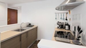 Eine moderne Küche mit Dunstabzugshaube aus Edelstahl, einer Spüle mit zwei Becken und Holzschränken.