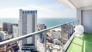 A balcony with a view of a cityscape and the ocean.