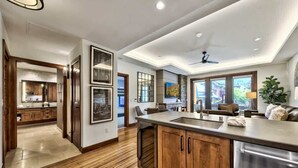 A modern kitchen with wooden cabinets, a large island, and a dining area with a view. - Luxury @Heavenly, Pool, Hot Tub, 6 Beds, Game Room (South Lake Tahoe)
