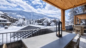 A snow-covered mountain resort with a wooden deck and a view of the resort buildings. - Luxury @Heavenly, Pool, Hot Tub, 6 Beds, Game Room (South Lake Tahoe)
