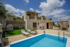 A stone villa with a pool, two lounge chairs, and a pergola. - Stoney Villa Koxari By Estia (Hersonissos)