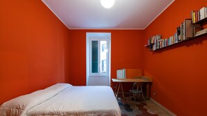 Een kamer met een bed, een bureau en een boekenkast.