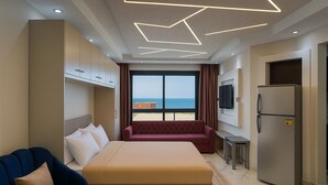 Ein Hotelzimmer mit einem Bett, einer Couch, einem Fernseher und einem Kühlschrank.