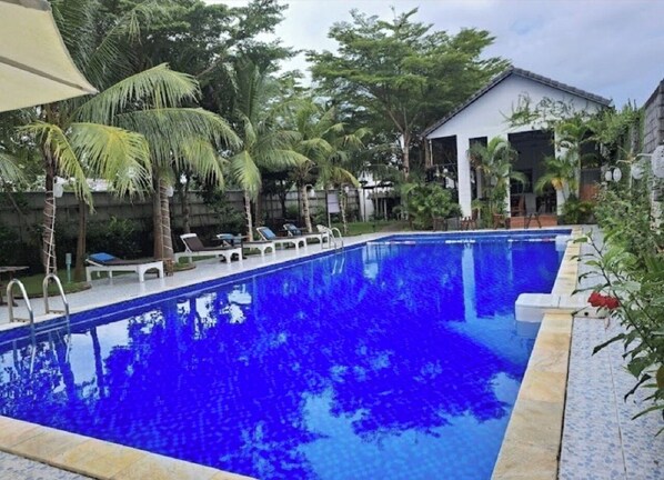Una piscina al aire libre, tumbonas