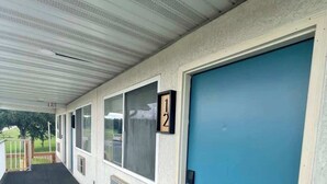 A corridor with a blue door, numbered room signs, and a covered walkway. - Stand Rock Studios in Wisconsin Dells! (Wisconsin Dells)