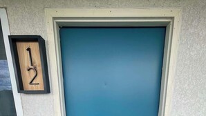 A blue door with a white frame, a small window above it, and a wooden mailbox with the number '12' on the wall. - Stand Rock Studios in Wisconsin Dells! (Wisconsin Dells)