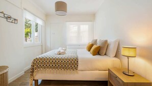 A bedroom with a bed, bedside lamp, and a window. - Monte Estoril Seabreeze by Portugal Portfolio (Estoril)