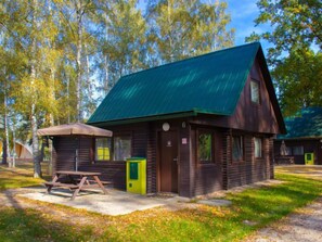 A rustic cabin with a green roof, a picnic table, and a small porch area. - Kemp Stříbrný rybník by Interhome (Hradec Kralove)